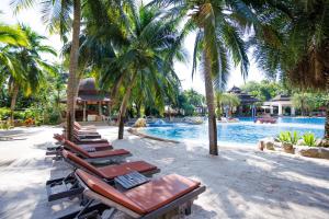a row of lounge chairs next to a swimming pool at Springfield Village Golf & Spa in Cha Am