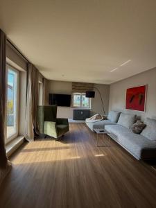a living room with a couch and two chairs at CASAMA am See in Langenargen
