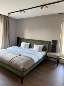 a bedroom with a bed with a couch and a chair at CASAMA am See in Langenargen