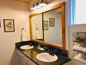 a bathroom with two sinks and a large mirror at Large Deck & Spa & Games & Vaulted Ceiling Cabin in Groveland