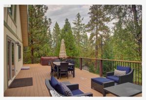 a deck with chairs and a table with a view of trees at Large Deck & Spa & Games & Vaulted Ceiling Cabin in Groveland