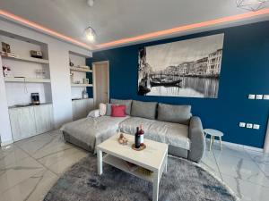 a living room with a couch and a table at Luxury Villa Rafaela Οικογενειακή βίλα με ιδιωτική πισίνα, BBQ κ παιχνίδια Ιδανική για οικογένειες με παιδια in Grevena +68 photos