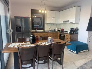 a kitchen with a wooden table with chairs and a refrigerator at Luxury Villa Rafaela Οικογενειακή βίλα με ιδιωτική πισίνα, BBQ κ παιχνίδια Ιδανική για οικογένειες με παιδια in Grevena