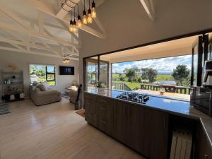 a kitchen with a large window and a living room at Elephant View Homestead - Hydrangea Cottage in Plettenberg Bay