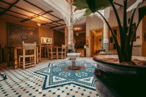 a living room with a fountain on a tiled floor at Riad Bleu Azahraa in Safi