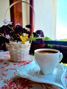 a cup of coffee sitting on a table with flowers at Shoposki Guest House in Ohrid