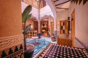 a living room with a tile floor and a building at Riad Bleu Azahraa in Safi