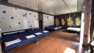 a room with two beds and a rock wall at Hills Queen Resort And Camping in Mohan Chatti