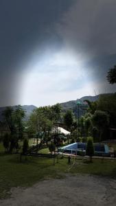 a view of a park with a playground with a bus at Hills Queen Resort And Camping in Mohan Chatti