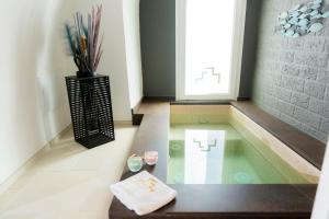 a jacuzzi tub in a room with a vase at Monsignore Luxury Suite in Monopoli