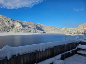 a snow covered fence next to a body of water at HOL Familie Hous in Hol