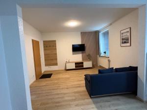 a living room with a blue couch and a tv at Ferienwohnung Sofia in Marl