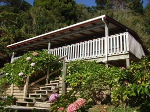 a set of stairs leading to a house with flowers at The Lodge At Te Rawa in Te Rawa