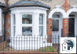 a white house with a sign in front of it at Contactor Stay, Reading Town Centre 4 Bed House, Large House with 2 bath in Reading
