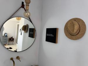 a mirror on a wall with a hat on it at 105 On Beach, Whale Room in St. Helena Bay