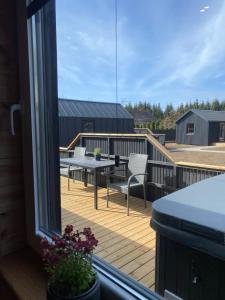 a balcony with a table and chairs on a deck at Trijų namelių uostas in Dreverna +8 photos