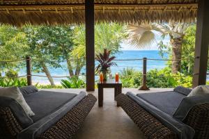 a living room with a view of the ocean at Manga Soa Lodge in Fascène - Befefika