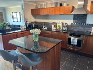 a kitchen with a vase of flowers on a counter at Aigua Blava in Carbis Bay