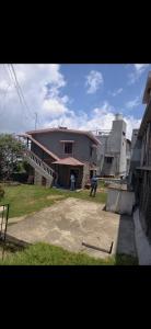 a house with a person standing in front of it at NILORA stay KODAI in Kodaikānāl +1 photo