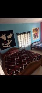 a bedroom with a bed with a comforter and a window at NILORA stay KODAI in Kodaikānāl