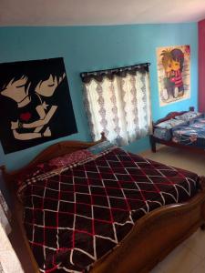 a bedroom with a bed and posters on the wall at NILORA stay KODAI in Kodaikānāl