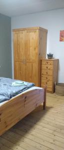 a bedroom with a wooden bed and a wooden dresser at Otto`s Ferienwohnung in Biedenkopf +3 photos