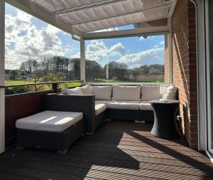 a outdoor patio with a couch and a window at Haus Sonnenwest in Rosengarten