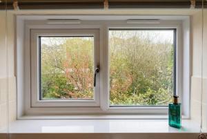 a window in a bathroom with a view of trees at New Forest Flat Steps from Brockenhurst Station, Sleeps 4 in Brockenhurst
