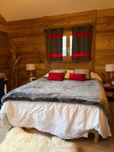 a bedroom with a bed with two red pillows at Charmante chambre Chalet in Crozet