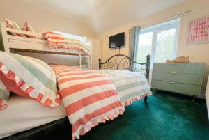 a bedroom with two bunk beds and a window at New Forest Flat Steps from Brockenhurst Station, Sleeps 4 in Brockenhurst
