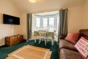 a living room with a couch and a table at New Forest Flat Steps from Brockenhurst Station, Sleeps 4 in Brockenhurst
