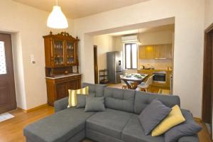 a living room with a gray couch and a kitchen at Pine Cottage, Syros Island in Firókambos +42 photos
