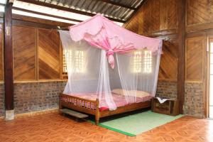 a bedroom with a bed with a mosquito net at Mama Pham Homestay in Tả Van
