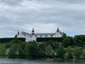 a large white building on a hill next to a lake at Seeblick Labud 20 Bosau in Bosau