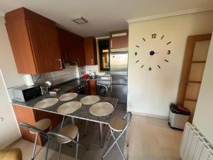 a kitchen with a counter with a clock on the wall at Paraiso Spa Reinante in San Miguel de Reinante