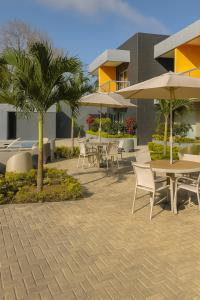 a patio with tables and chairs and umbrellas at Tibisay Hotel Boutique Morrocoy in Tucacas