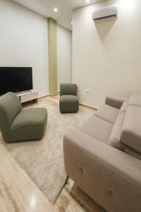 a living room with a couch and two chairs and a tv at Tibisay Hotel Boutique Morrocoy in Tucacas