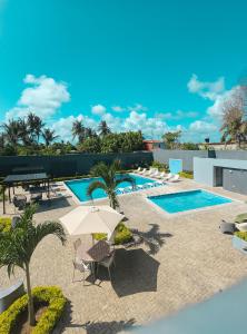 a patio with an umbrella and a pool at Tibisay Hotel Boutique Morrocoy in Tucacas