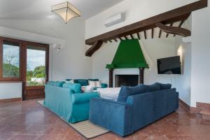 a living room with two blue couches and a fireplace at Panther Home El Ancla Villa Premium con Piscina Privada in El Puerto de Santa María