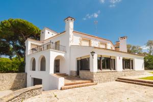 a large white house with a stone wall at Panther Home El Ancla Villa Premium con Piscina Privada in El Puerto de Santa María
