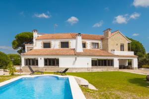 a villa with a swimming pool in front of a house at Panther Home El Ancla Villa Premium con Piscina Privada in El Puerto de Santa María