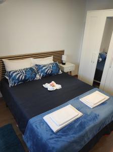 a bedroom with a blue bed with towels on it at Moradia Largo do Pátio in Sertã
