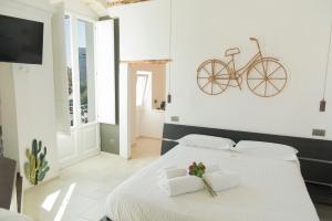a bedroom with a white bed with a bike on the wall at Monsignore Luxury Suite in Monopoli +126 photos