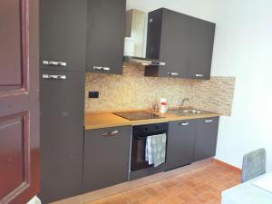 a kitchen with gray cabinets and a sink at La Finestra sul Corso 3 in Arcidosso +13 photos