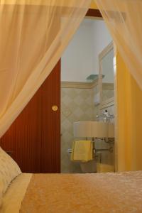a bathroom with a sink and a bed and a mirror at B&B Rita E Renzo in Riola Sardo