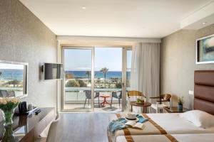 a hotel room with a bed and a view of the ocean at Faros Hotel Ayia Napa in Ayia Napa