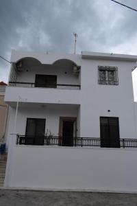a white building with a balcony on top of it at Art House by Helen in Soroni Rhodes in Rhodes Town