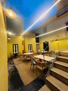 a dining room with tables and chairs and stairs at U-Hotel Aduana Ribadeo in Ribadeo