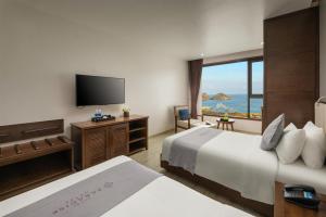 a hotel room with two beds and a flat screen tv at Cat Ba Paradise Hotel - Sky Bar & Massage in Cat Ba
