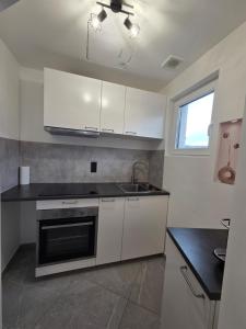 a kitchen with white cabinets and a sink at Flexi flat Gosselies Providence 11 in Charleroi +2 photos